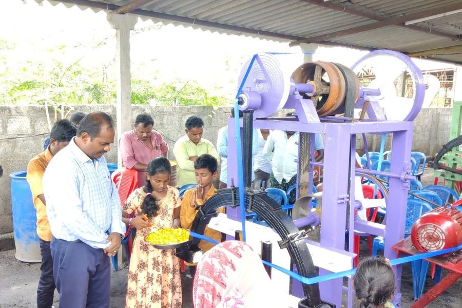 With children beside a small workshop machine
